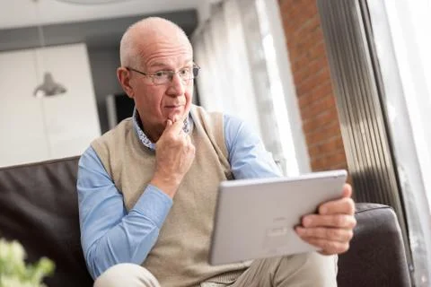 Smiling senior man using a digital tablet Foto stock