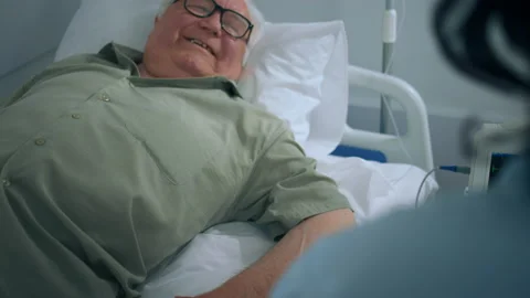 Smiling senior man while is laying down on the hospital bed he is recover his Video stock 209961919