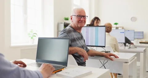 Smiling senior student in computer training classroom during adult learning Stock Footage 343299605
