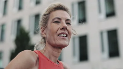 Smiling senior woman in sport clothes standing on street Stock Footage 167497880