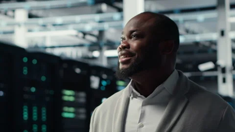 Smiling server room engineer performing maintenance on server racks Stock Footage 311832949