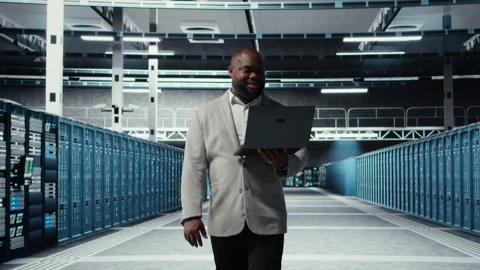 Smiling server room engineer performing maintenance on server racks Stock Footage 311960219
