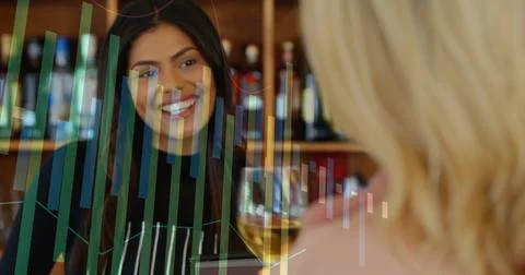 Smiling server wearing apron at wine counter with shelved bottles, serving Stock Photos