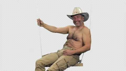 Smiling shirtless middle aged man in cowboy hat relaxing on beach swing, alpha Stock Footage 306096501