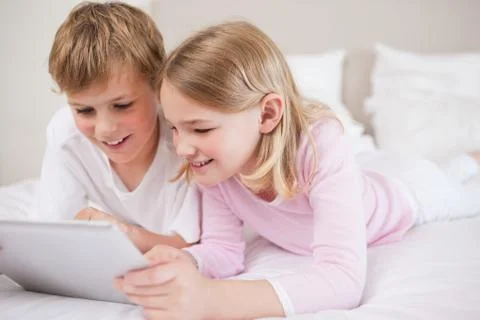 Smiling siblings using a tablet computer Foto stock