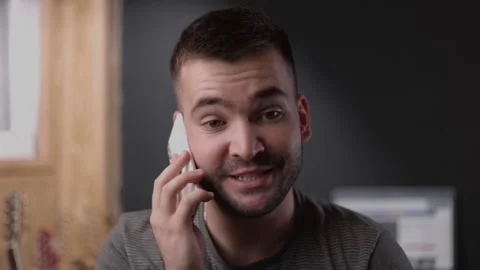 Smiling sincere young man communicating distantly by cell phone call Stock Footage 163703259