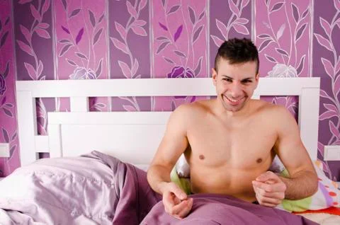 Smiling single man in the bed Stock Photos