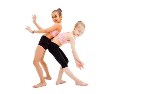 Smiling sisters gymnasts isolated on white. Stock Photos