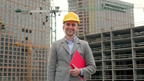 Smiling site inspector posing for camera against new buildings Stock Footage 274389968