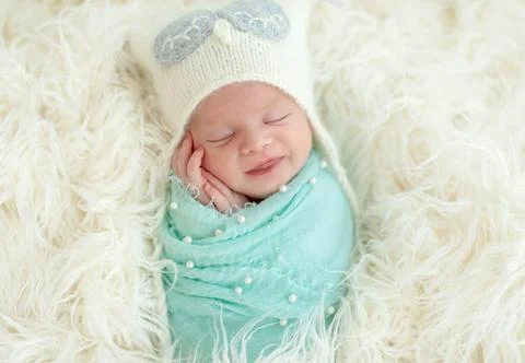 Smiling sleeping newborn kid Stock Photos
