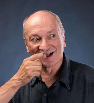 Smiling sly elderly man 库存照片