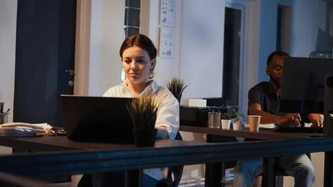 Smiling software developer planning network report on laptop Foto stock