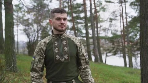 Smiling soldier in uniform greeting while walking outdoors. Slow-motion Stock Footage 234086999