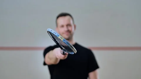 Smiling Squash Player Raises Racket Toward Camera in Slow Motion Shot Stock Footage 322149724