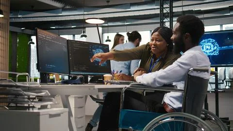 Smiling startup engineer and colleague with disability brainstorming, using AI Stock Photos