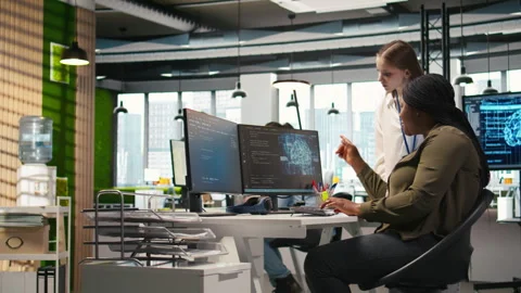 Smiling startup manager teaching junior dev how to use machine learning tech Stock Footage 313016717