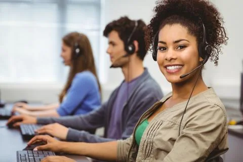 Smiling student with headset using computer Stock Photos