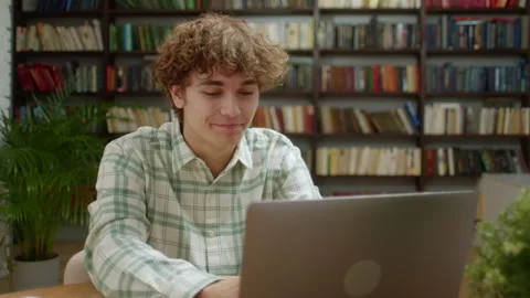 Smiling Student Man Working on Laptop Computer at Home Office or Library. Male Видео 172018991