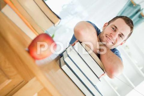Smiling student with a pile of books Stock Photos