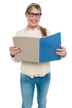 Smiling student reading from her note book Stock Photos