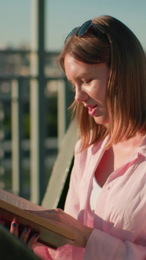 Smiling Student Sharing Book Outdoors in Urban Sunlit Setting Stock Footage 317583160