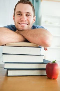 Smiling student with a stack of books Stock Photos