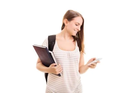 Smiling student with textbooks checking her phone Stock Photos