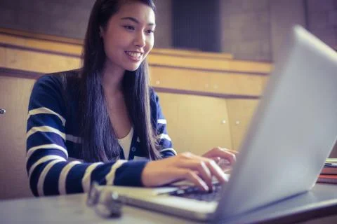 Smiling student using laptop 스톡 사진
