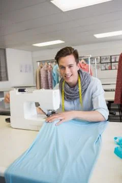 Smiling student using sewing machine 스톡 사진