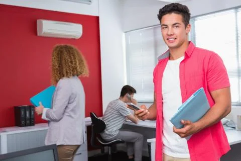 Smiling student using smartphone near classmates Stockfoto's