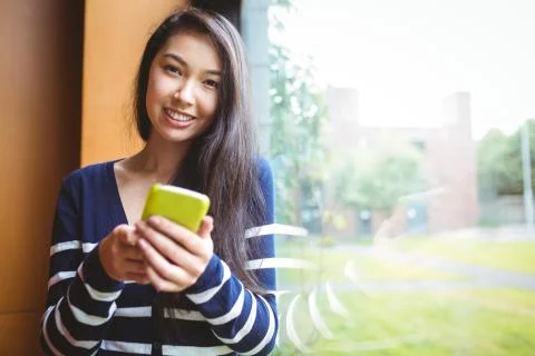 Smiling student using smartphone 스톡 사진