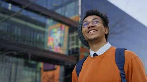Smiling student walking to college campus in urban area Stock Footage 310717446