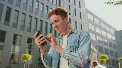 Smiling student young handsome man with red hair sitting on a bench near Stock Footage 142050137