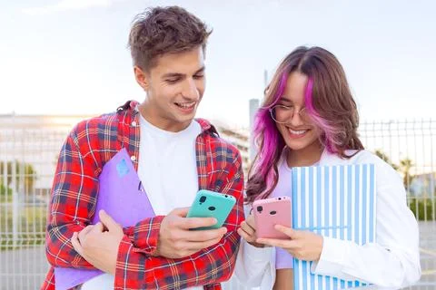 Smiling Students Sharing Smartphone Content Outdoors Stock Photos