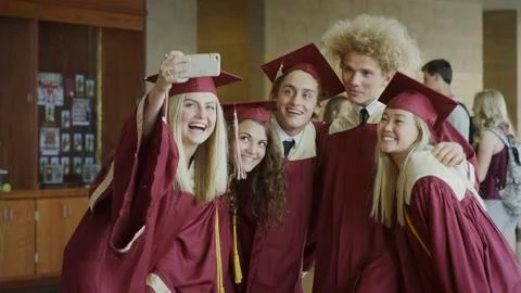 Smiling students taking smartphone camera selfie together at graduation 스톡 사진