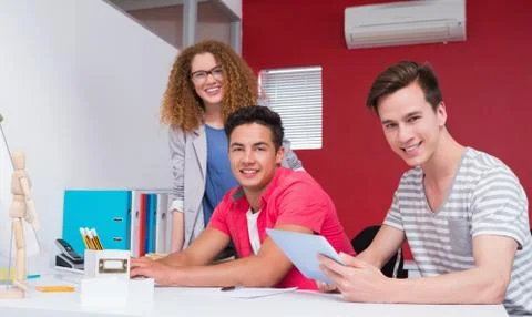 Smiling students using computer and tablet together Stock Photos