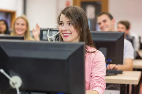 Smiling students using computers in computer room 스톡 사진