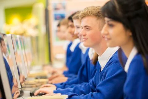 Smiling students using computers in computer room Foto stock