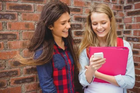 Smiling students using smartphone 写真素材