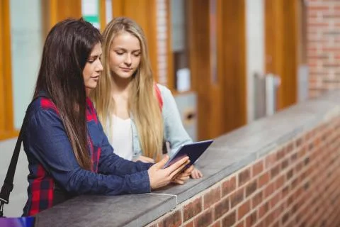Smiling students using tablet together 스톡 사진