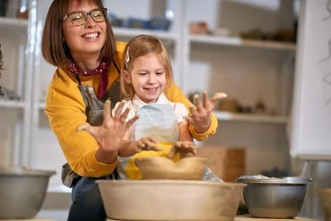 Smiling studnet with dirty hands while making pot from clay on pottery work.. Stock Photos