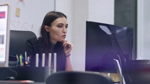 Smiling stylish brunette works at a computer. Business woman in a modern office Stock Footage 105655647