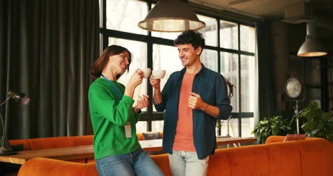 Smiling successful colleagues drinking coffee during pleasant break enjoying Stock Footage 322216104