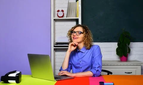 Smiling teacher or student using laptop sitting at desk studying online. Teac Stock Photos