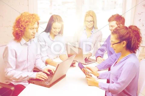 Smiling team with laptop and table pc computers Stock Photos