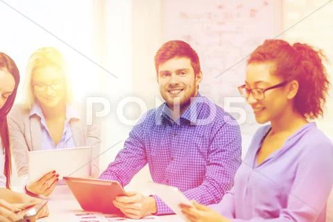 Smiling team with table pc and papers working Stock Photos