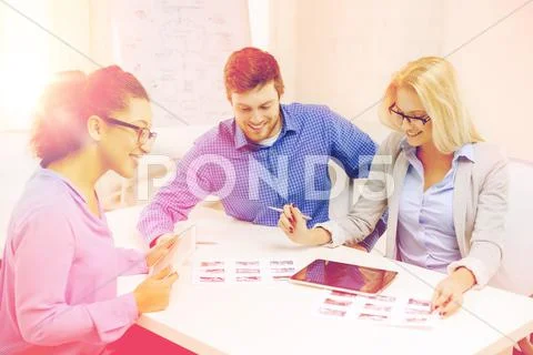 Smiling team with table pc and papers working Stock Photos