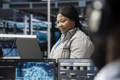 Smiling technician in data center uses AI for machine learning workloads 스톡 사진