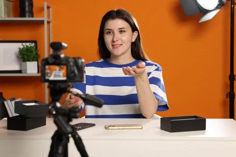 Smiling technology blogger explaining something while recording video at home Stock Photos