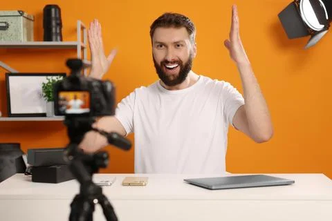 Smiling technology blogger explaining something while recording video at home Stock Photos